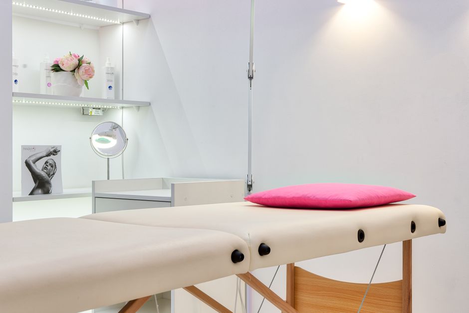 Interior of modern beauty office with couch for skincare procedures under glowing light