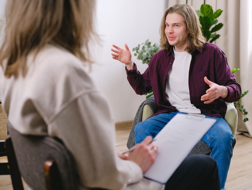 A therapist and patient in a conversational therapy session indoors.