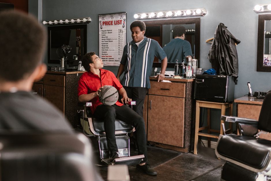 A bustling barbershop with customers engaged in conversation, surrounded by classic decor.