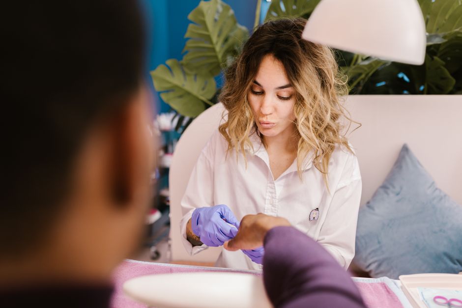 A woman providing a manicure service in a nail salon, showcasing self-care and professionalism.
